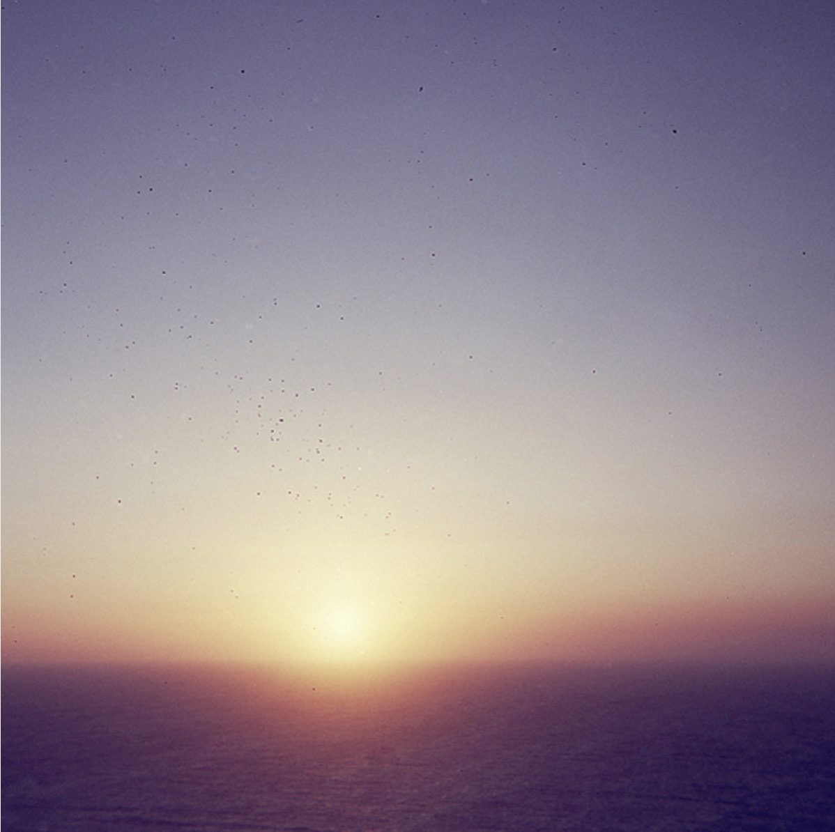 The sun setting low over the sea